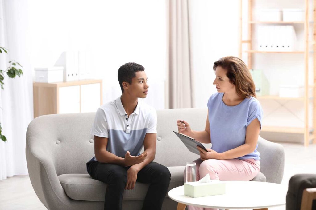 a teen speaking with a counselor 